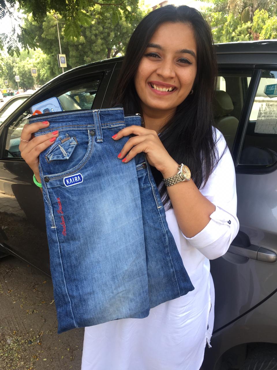 Customer holding a tote bag made from her own pair of jeans with her name embroidered