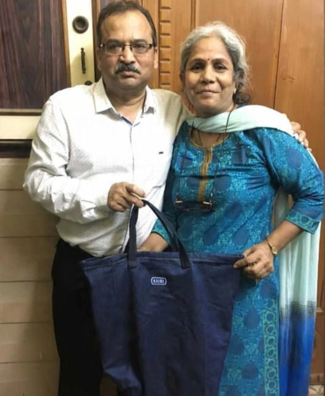 Couple holding a large dark denim tote bag made by KAIRA.ADDON