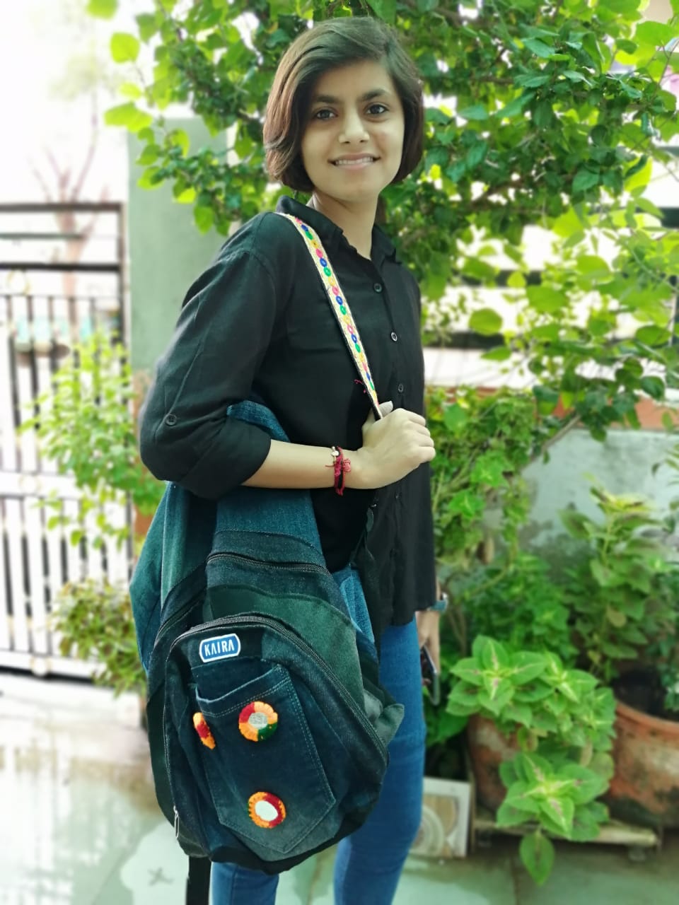 Customer wearing a denim backpack with an embroidered beaded strap